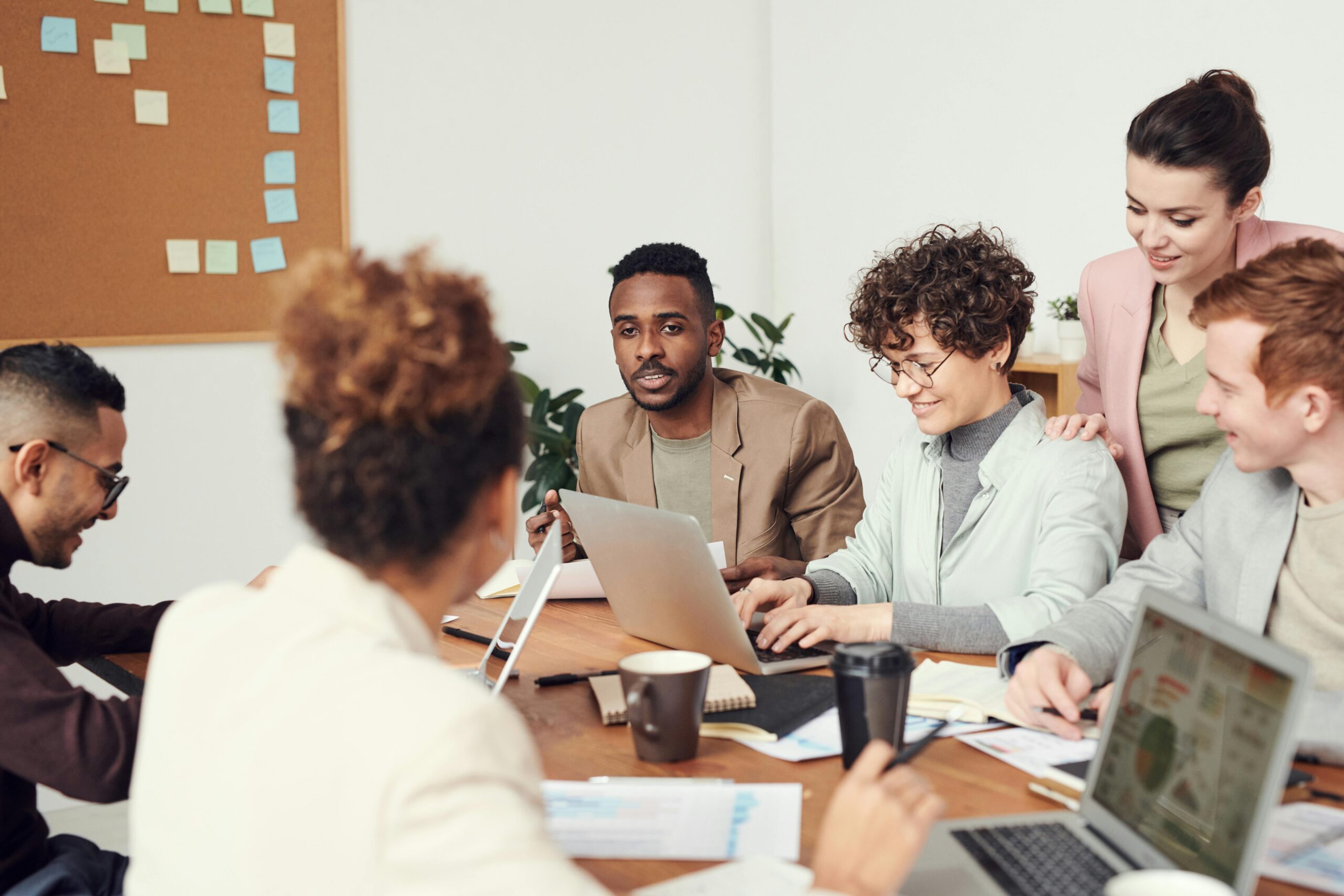 Office workers gathered around the table against a gray background.
