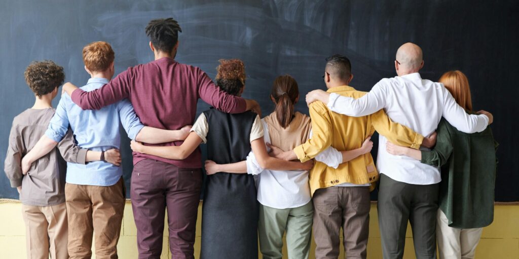 Coworkers locking arms against a black backdrop