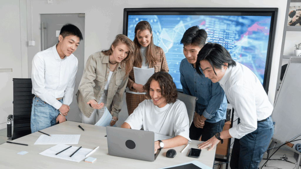 Team gathered around a laptop.