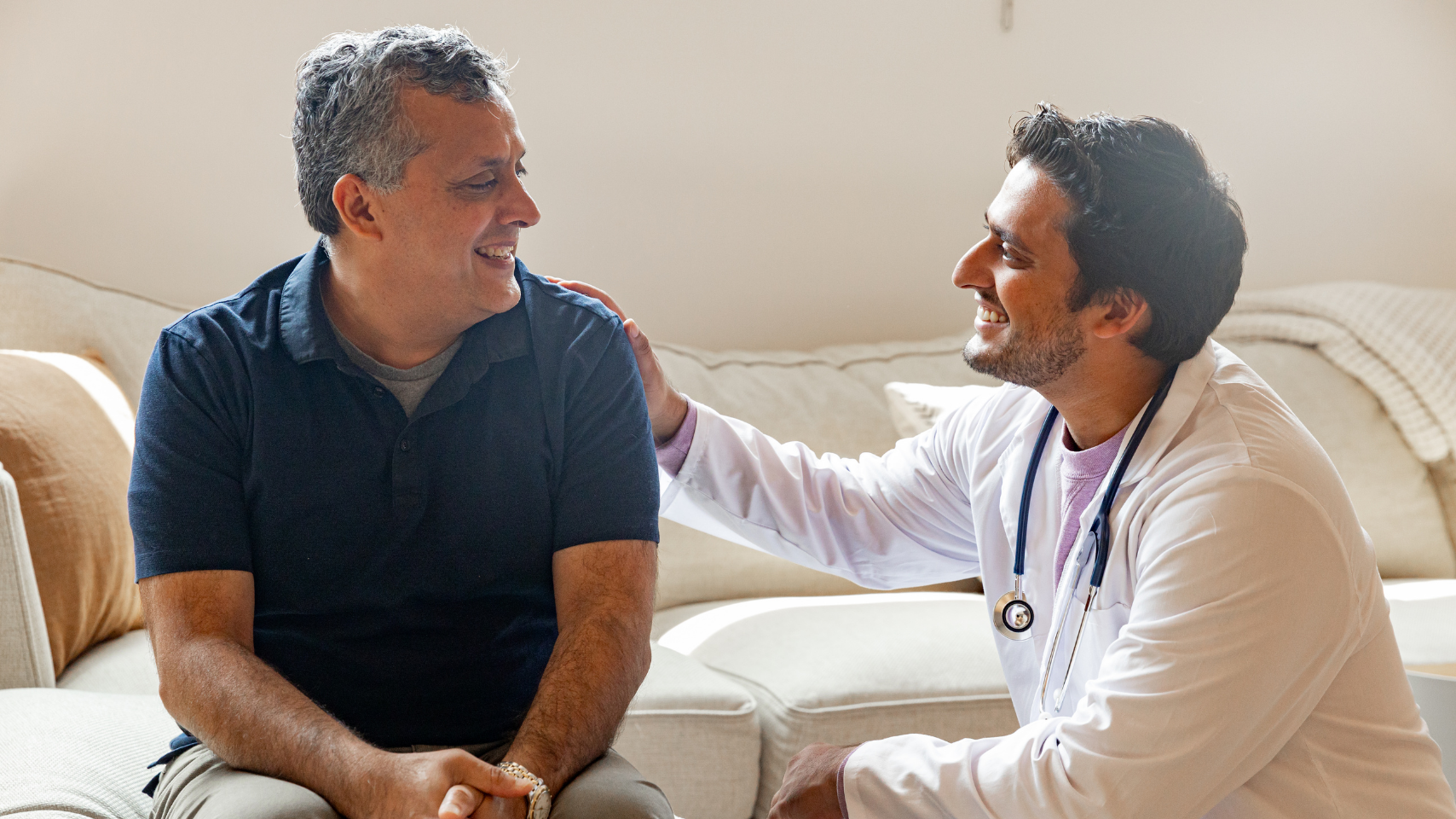 Male doctor comforting male patient
