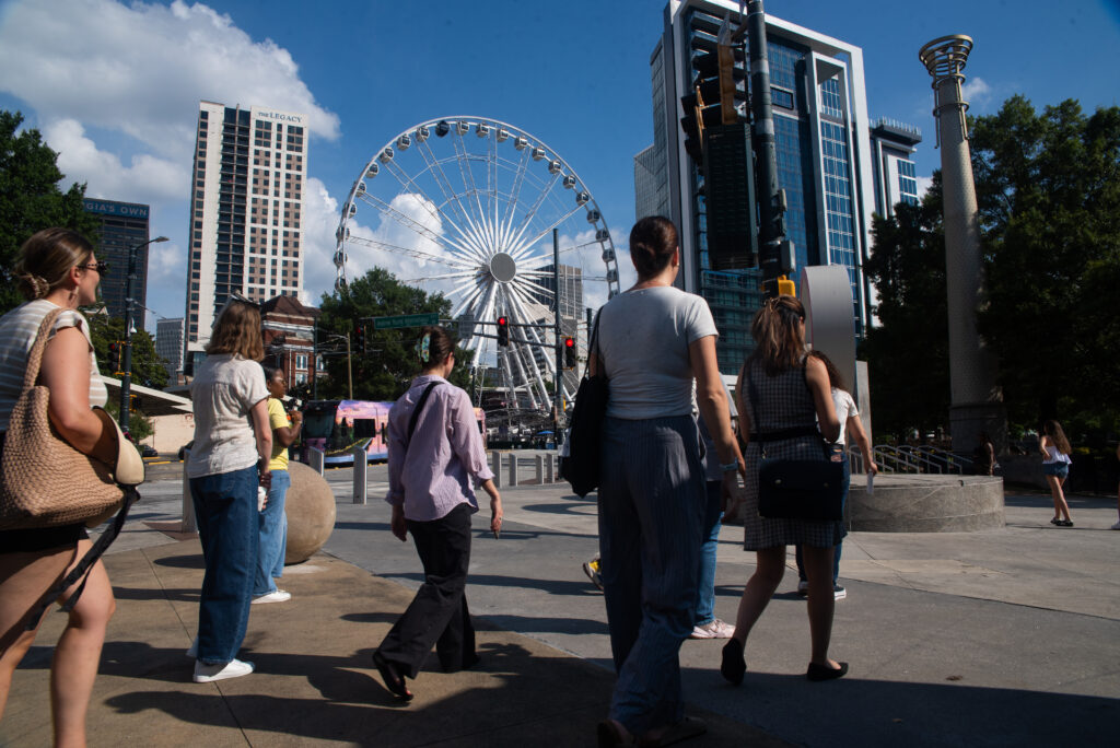 A group of NationSwell members walk past the icon ferris wheel in Atlanta