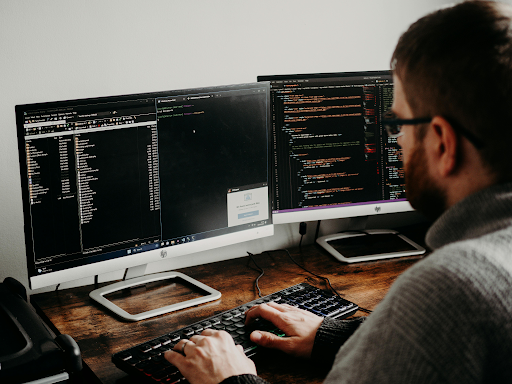 Man coding on desktop computer